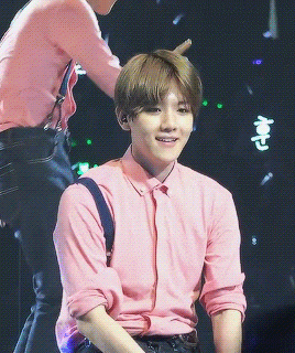 The Young Man Is Wearing A Pink Shirt And Black Pants